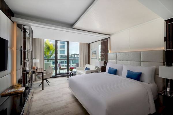 Schlafzimmer im Marriott Resort Palm Jumeirah in Dubai mit großem Bett, Fenstern und Stadtblick