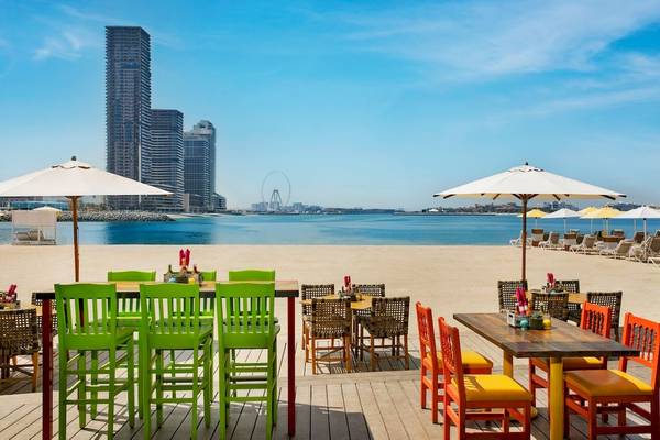 Strandbereich des Marriott Resort Palm Jumeirah in Dubai mit bunten Stühlen und Tischen.
