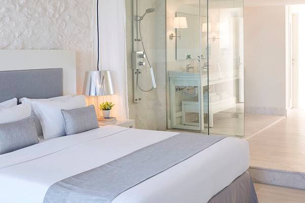 Schlafzimmer im Knossos Beach Bungalows Suites Resort & Spa mit einer Dusche und einem Bett