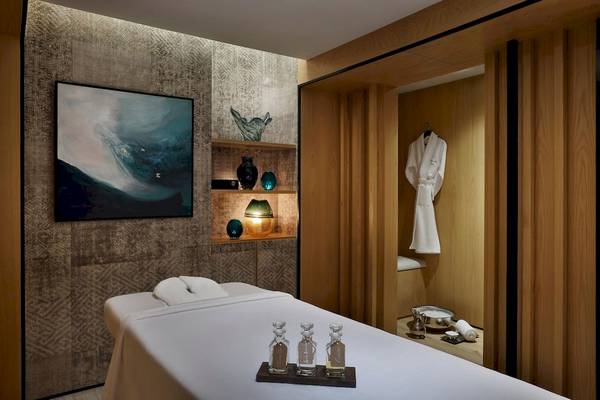 Spa-Behandlungsraum im Marriott Resort Palm Jumeirah, Dubai, mit Behandlungsliege, Dekor und Zubehör.