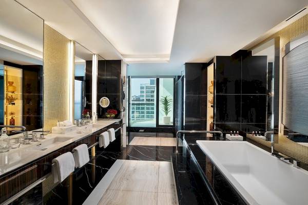 Luxuriöses Badezimmer im Marriott Resort Palm Jumeirah, Dubai mit schwarzen Marmorwänden und weißen Armaturen.