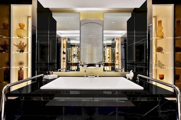 Luxuriöses Badezimmer im Marriott Resort Palm Jumeirah, Dubai, mit Marmorboden und goldenen Akzenten.