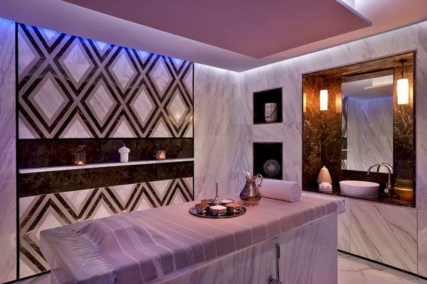 Spa-Bereich im Marriott Resort Palm Jumeirah, Dubai, mit marmornen Wänden und violetten Lichtern.