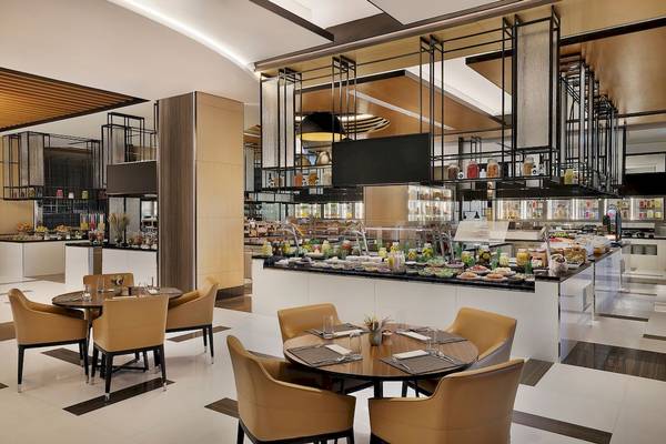 Innenbereich des Restaurants im Marriott Resort Palm Jumeirah in Dubai mit vielen Tischen und Stühlen.