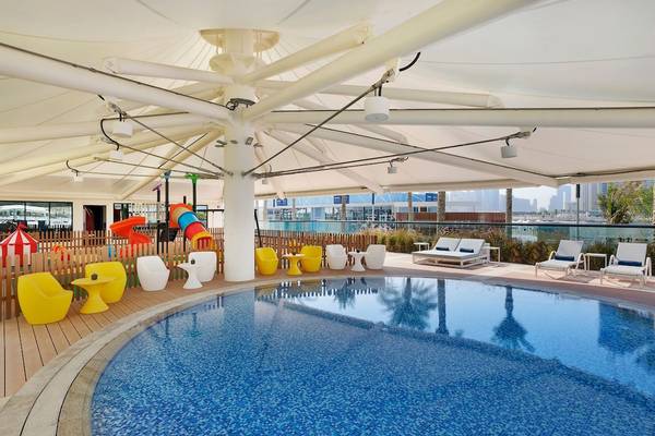 Außenpoolbereich des Marriott Resort Palm Jumeirah in Dubai mit bunten Stühlen und Spielplatz