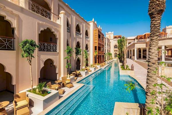Außenansicht des Grand Palace Hotels mit großem Pool und Loungebereichen.