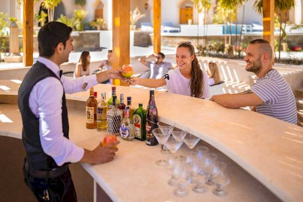 Ein Barkeeper reicht einen Cocktail im Grand Palace.