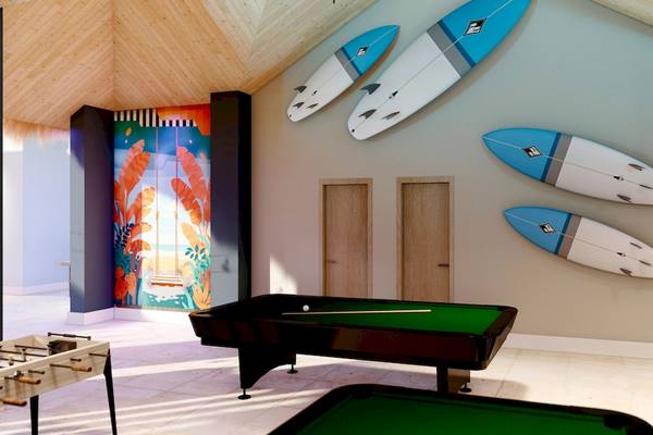Spielzimmer im Hotel Sunscape Dominicus La Romana mit zwei Billardtischen, Surfbrettern an der Wand und einem Fußballtisch.