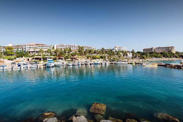 Blick auf die Marina mit vielen geparkten Booten und dem Coral Beach Hotel & Resorts im Hintergrund.