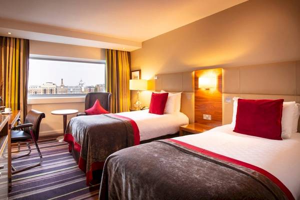 Hotelzimmer im Tower Hotel, London mit zwei Betten, Fernseher und Schreibtisch.