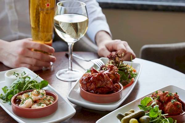 Ein Tisch im Tower Hotel, London, mit verschiedenen Gerichten und Getränken wie Wein und Bier.