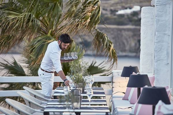 Ein Kellner serviert Getränke auf der Terrasse des Archipelagos Hotels.