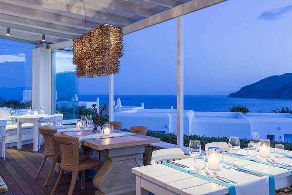 Außenbereich des Archipelagos Hotels mit gedeckten Tischen und Blick auf das Meer.