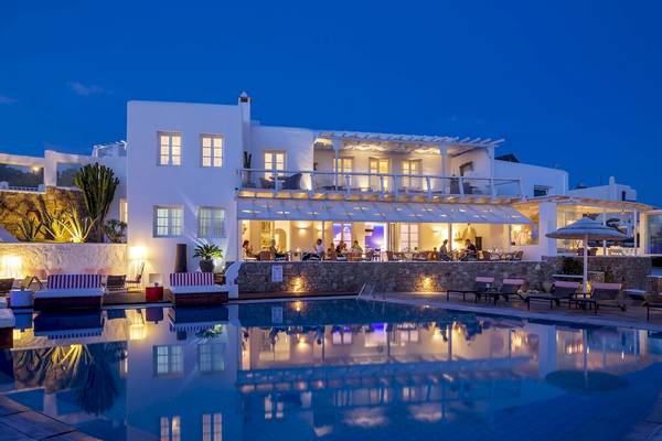 Nachtansicht des Archipelagos Hotels mit Pool, Außenbeleuchtung und Gäste am Abendessen.