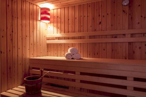 Innenansicht der Sauna im Archipelagos Hotel mit Holzbänken und aufgerollten Handtüchern.