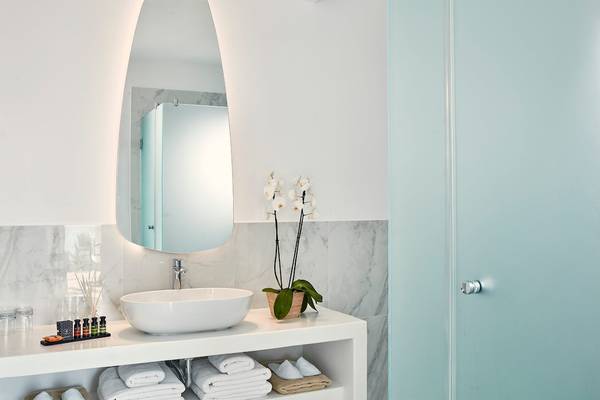 Badezimmer im Archipelagos Hotel mit großem Spiegel und Blumendekor