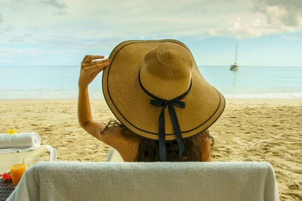 Ein Handtuch von Savoy Seychelles Resort & Spa liegt auf einem Stuhl am Strand.