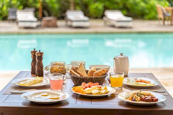 Frühstück am Pool im Bliss Hotel Praslin mit verschiedenen Speisen und Getränken