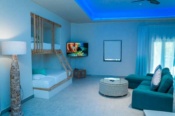 Schlafzimmer im Le Duc de Praslin Hotel mit Stockbett, Fernseher, Couch und Lampe