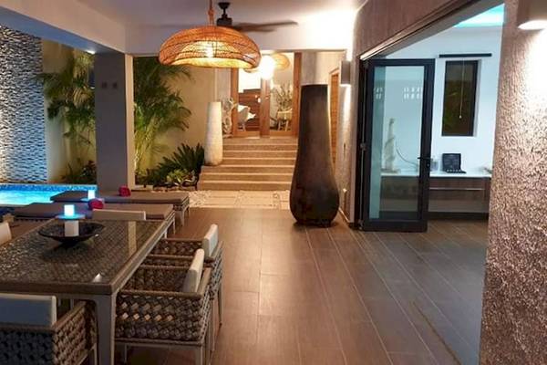 Außenbereich des Le Duc de Praslin Hotel & Villas mit Swimmingpool und Esstisch.