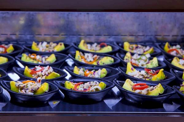 Mehrere Gerichte in schwarzen Schüsseln auf einem Buffet im Le Duc de Praslin Hotel & Villas.