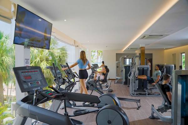 Fitness-Center im Le Duc de Praslin Hotel mit Cardiogeräten und Mitgliedern, die trainieren.