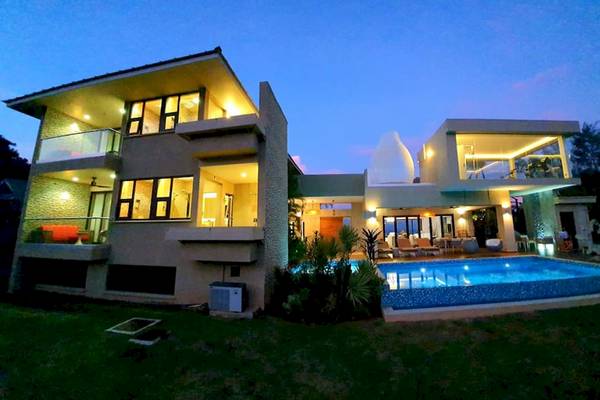 Außenansicht des Le Duc de Praslin Hotel & Villas bei Nacht mit beleuchteten Fenstern und Swimmingpool.