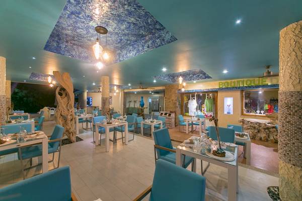 Innenbereich des Restaurants im Le Duc de Praslin Hotel mit blauen Tischen und Stühlen.