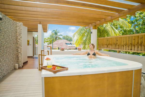 Eine Frau in einem Whirlpool auf der Terrasse des Le Duc de Praslin Hotels und Villas.