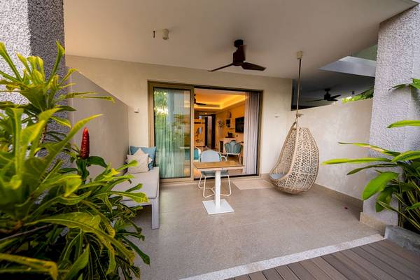 Terrasse des Le Duc de Praslin Hotel & Villas mit Hängesessel, Tisch und Sofa.