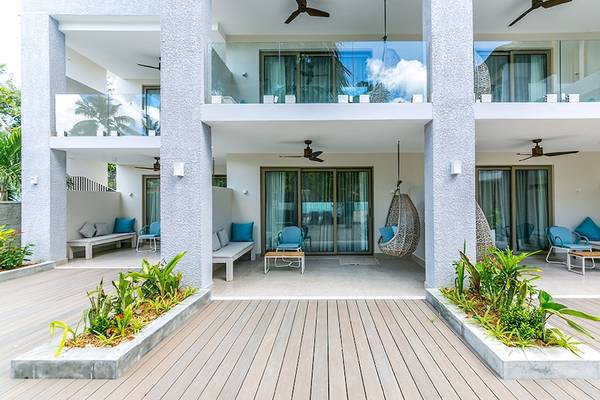 Außenbereich des Le Duc de Praslin Hotel & Villas mit Terrassen, Möbeln und Pflanzen.