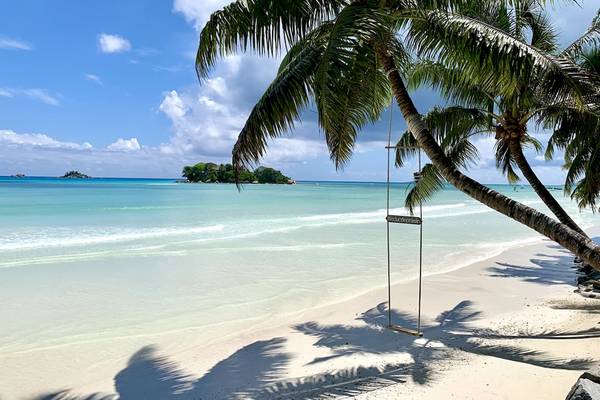 Le Duc de Praslin Hotel & Villas am Strand mit Palmen und einer Schaukel