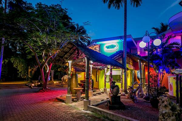 Nachtansicht des Le Duc de Praslin Hotel & Villas mit beleuchteten Gebäuden und Gehweg.