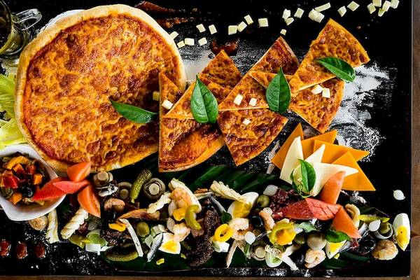 Eine kulinarische Speiseplatte mit einer Pizza und verschiedenen Meeresfrüchten im Le Duc de Praslin Hotel & Villas.