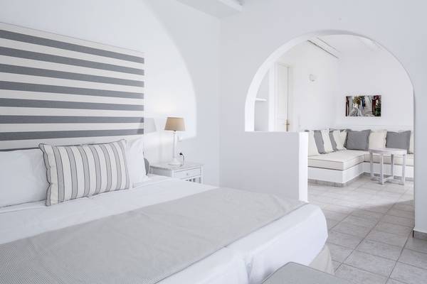 Schlafzimmer des Archipelagos Hotels mit weißen Möbeln und grauen Akzenten.