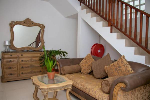 Wohnzimmer des Village du Pecheur Hotels mit Sofa, Tisch, Spiegel und Treppe.
