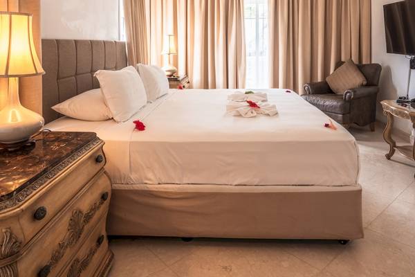 Doppelbett im Hotelzimmer des Village du Pecheur mit frischen Blumen und Möbeln.
