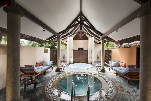 Innenbereich des Constance Lemuria Seychelles mit zwei kleinen Pools und Liegen.