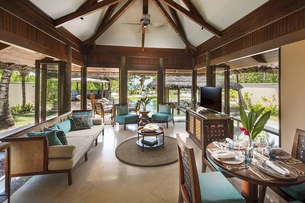 Wohnbereich im Constance Lemuria Seychelles mit Blick auf den Garten und Meer.