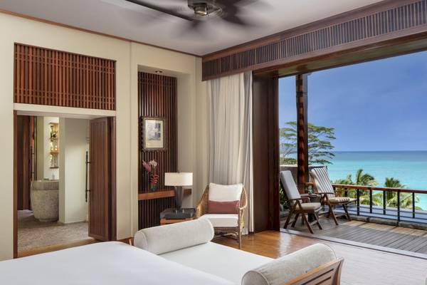 Balkonzimmer im Anantara Maia Seychelles Villas mit Meerblick, umgeben von Möbeln und einem Deckenventilator.