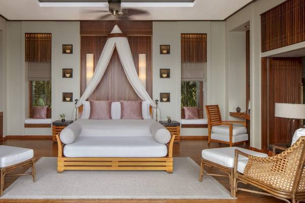 Schlafzimmer im Anantara Maia Seychelles Villas mit Bett, Möbeln und Fenstern