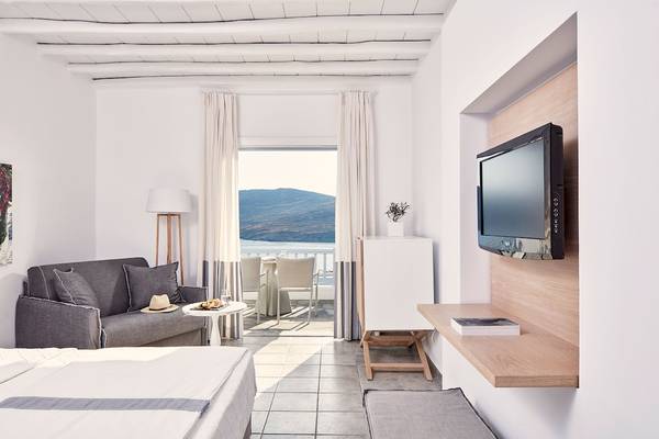 Innenansicht eines Zimmers im Archipelagos Hotel mit Blick auf eine Terrasse und einen Berg