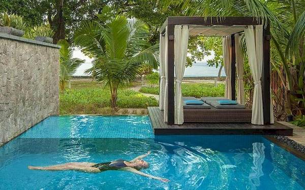 Eine Frau schwimmt in einem Pool des STORY Seychelles Hotels.