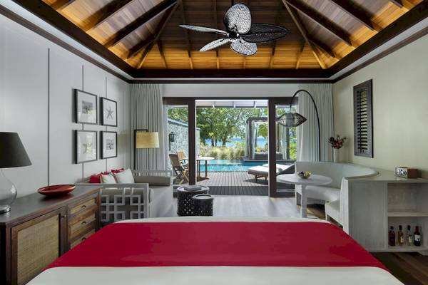 Innenansicht eines Zimmers im STORY Seychelles Hotel mit Blick auf den Pool und die Terrasse.