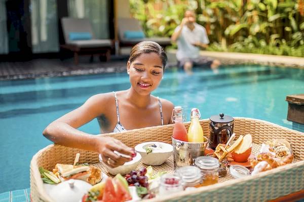 Frau genießt Frühstück im Pool am STORY Seychelles Hotel.