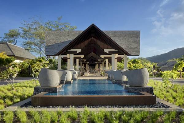 Außenansicht des STORY Seychelles Hotels mit Wasserbrunnen und grüner Landschaft