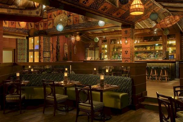 Innenbereich des STORY Seychelles Hotels mit Esstischen, Stühlen und Bar.