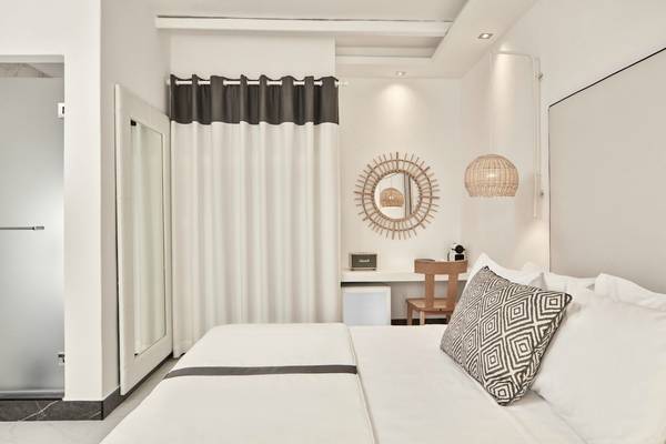 Schlafzimmer im Archipelagos Hotel mit Bett, Nachttisch und Spiegel