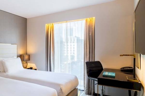 Doppelzimmer im Saint Hotel, London, mit zwei Betten, Schreibtisch und Stadtblick.