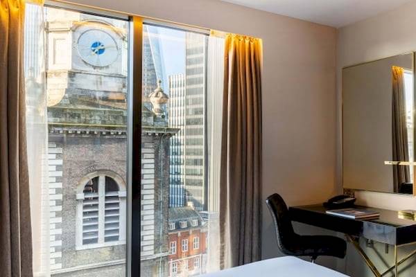 Zimmer im Saint Hotel, London mit Blick auf die Stadt und eine Uhr am Gebäude